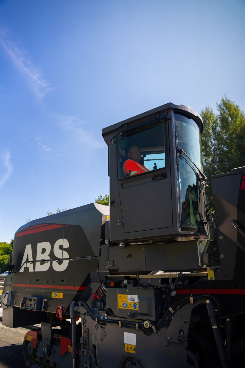 Kaltfräse von ABS mit Fahrerkabine vor blauem Himmel